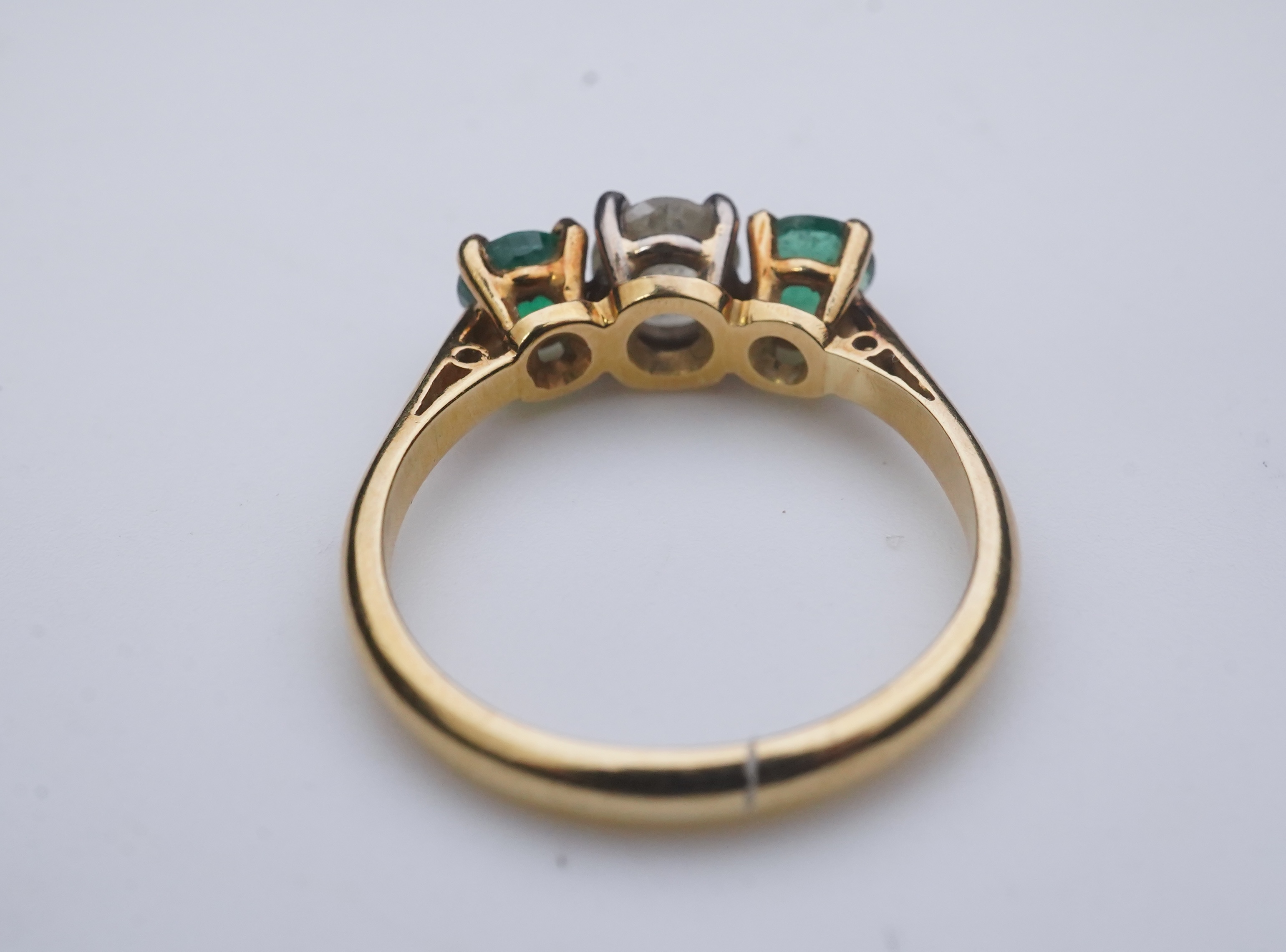 An emerald and diamond three-stone ring